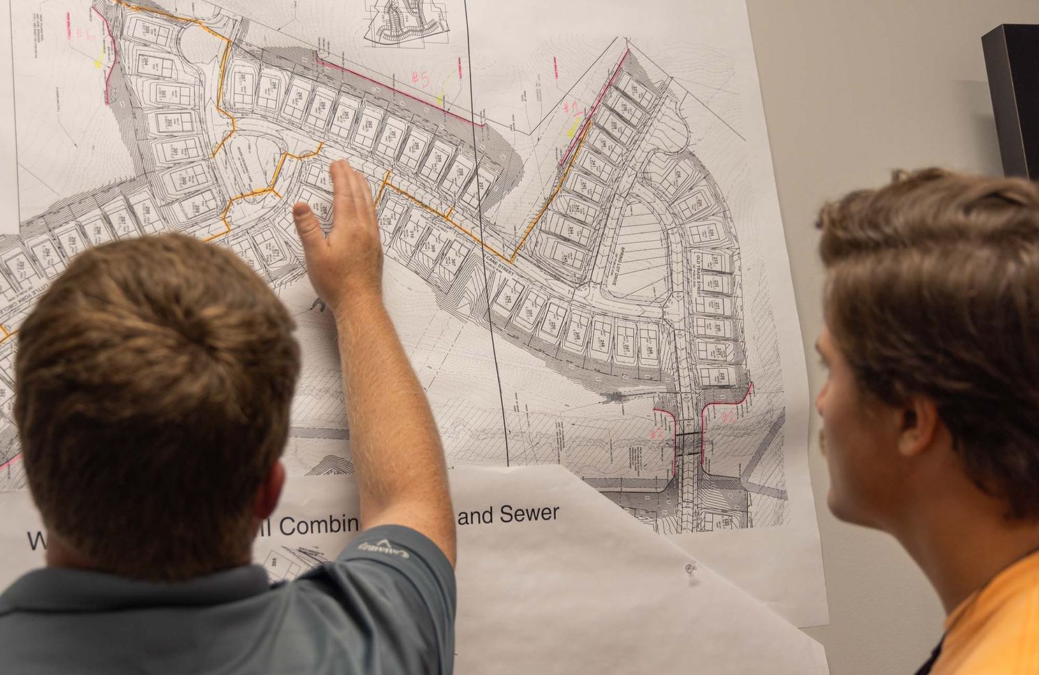 two men examining blueprints as part of career and technical education month
