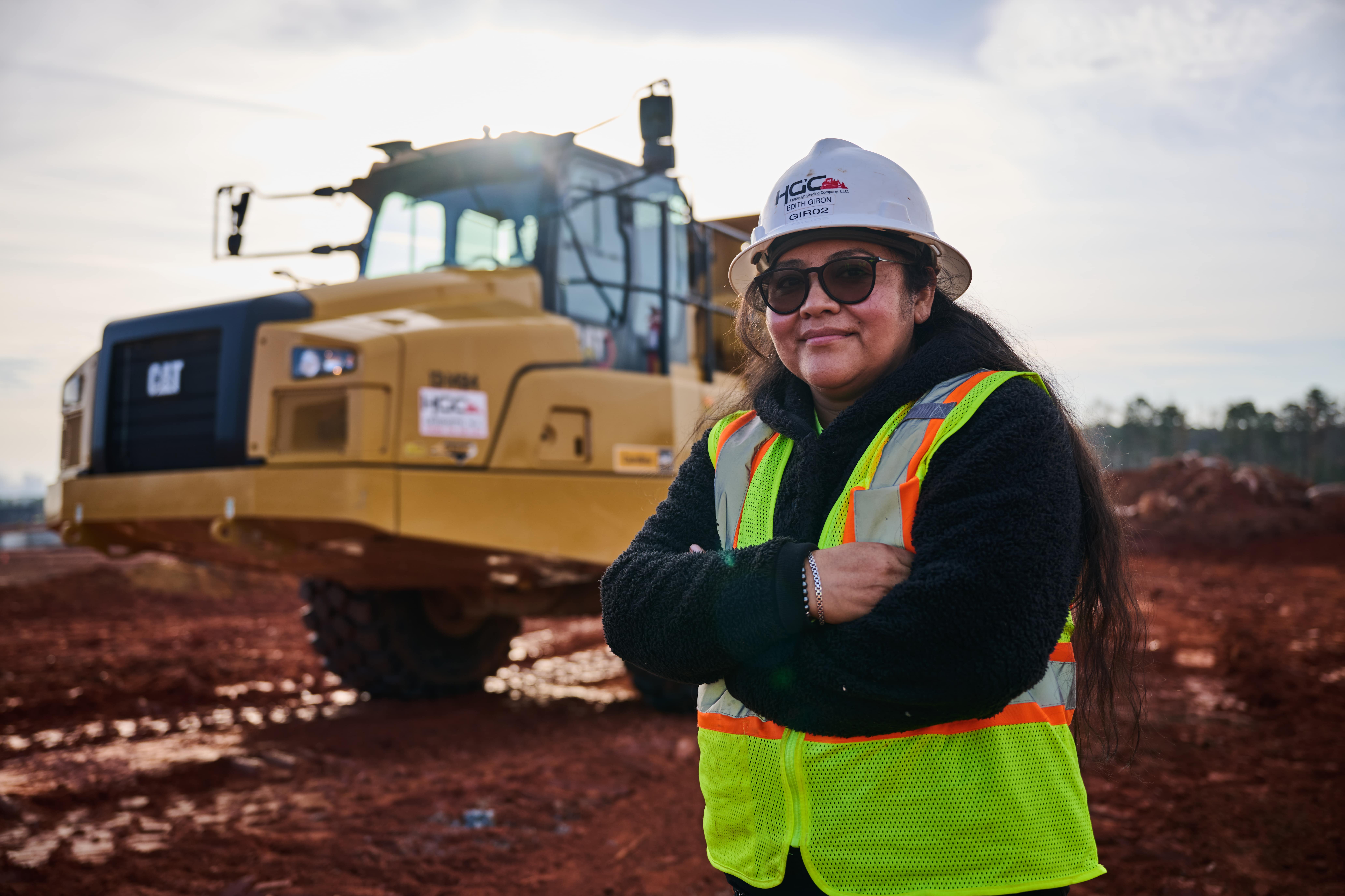 a female standing in front of a dozer