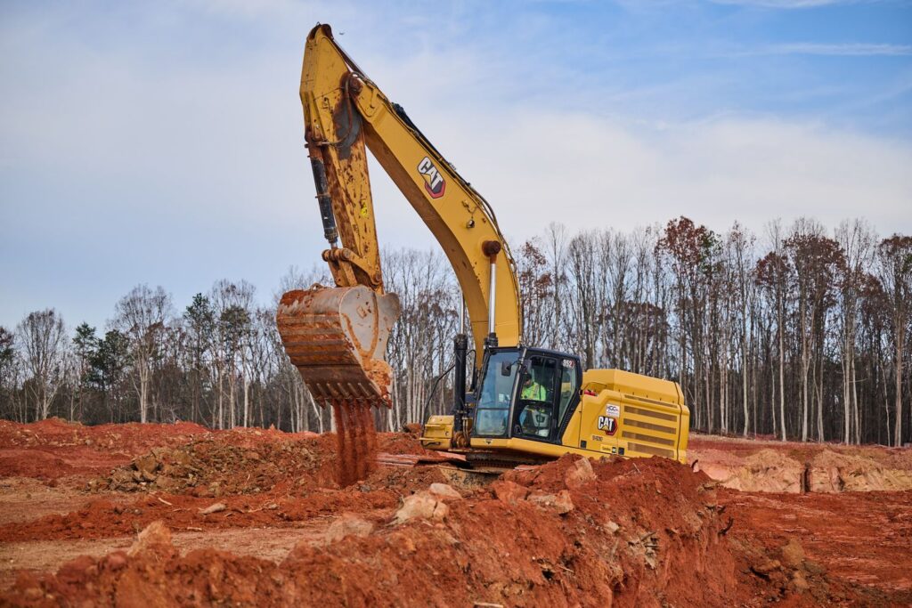 Excavator emptying dirt, a machine used by a commercial earthwork contractor