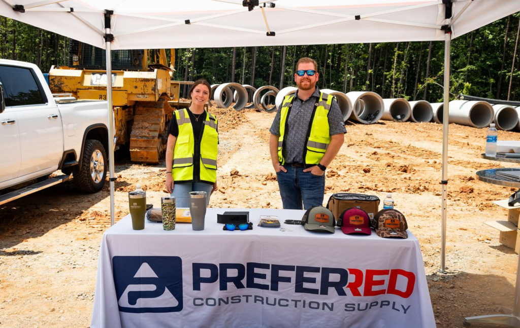 a oompany standing behind a booth at a job site