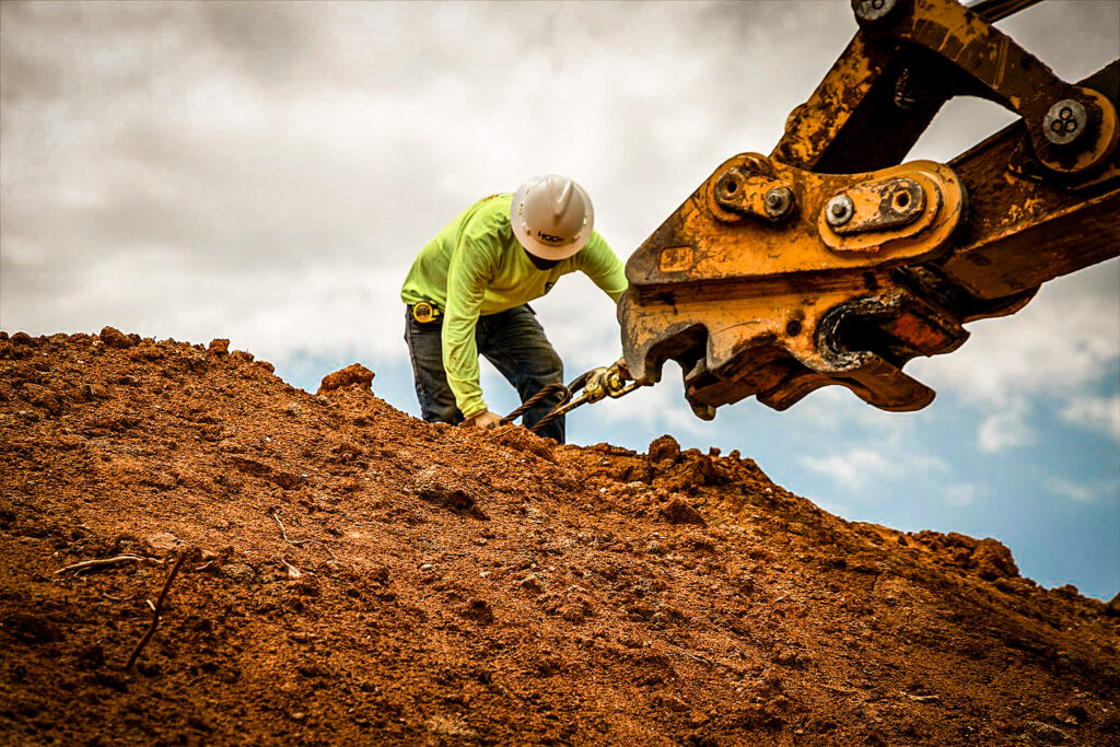 a construction worker working in dirt at a site construction zone