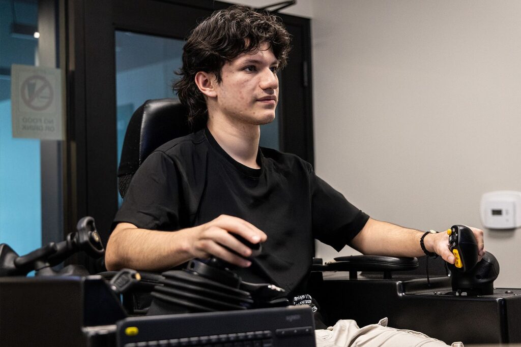 a young boy sitting on simulator during his construction intership